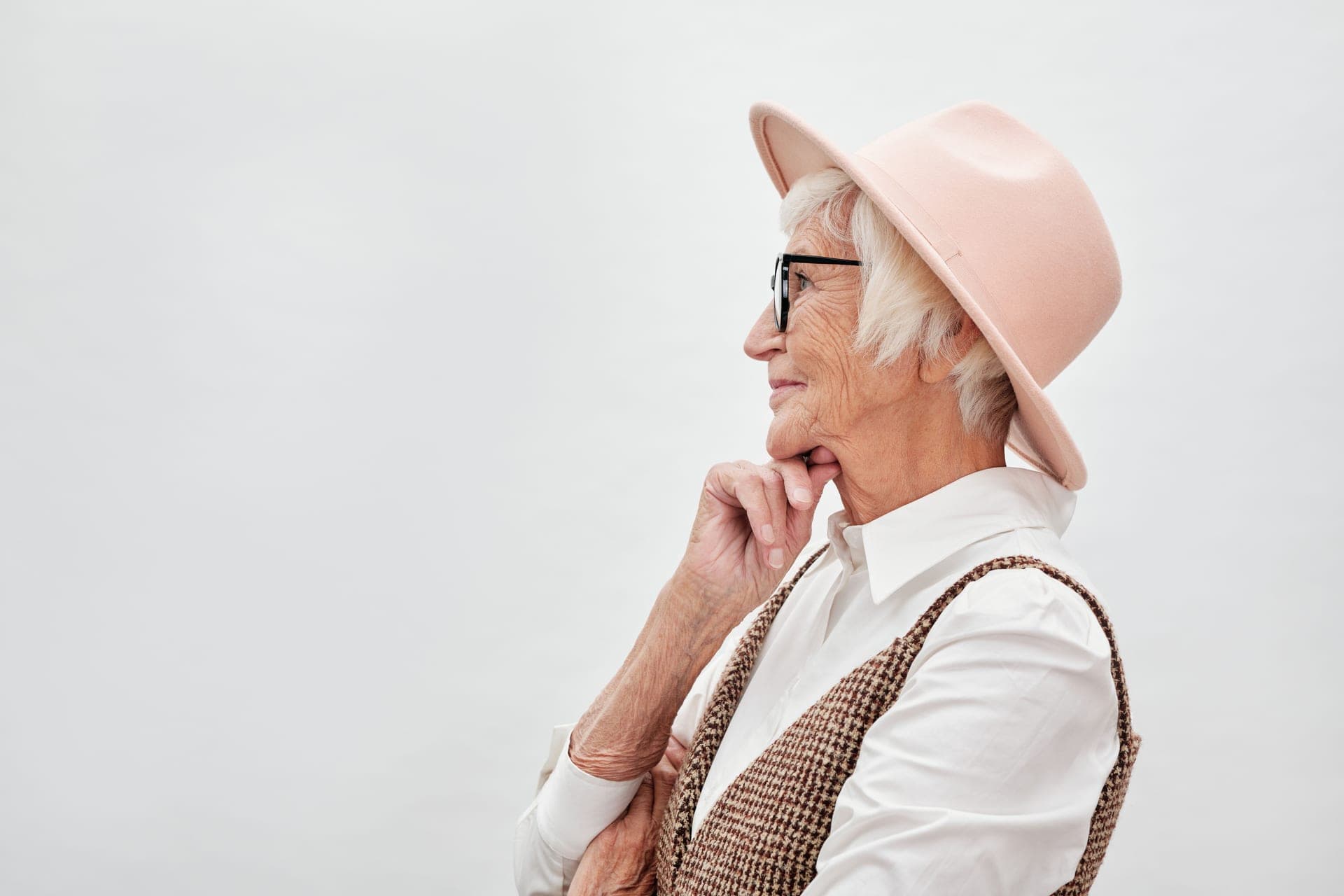 Side profile of a senior woman wearing glasses and a hat