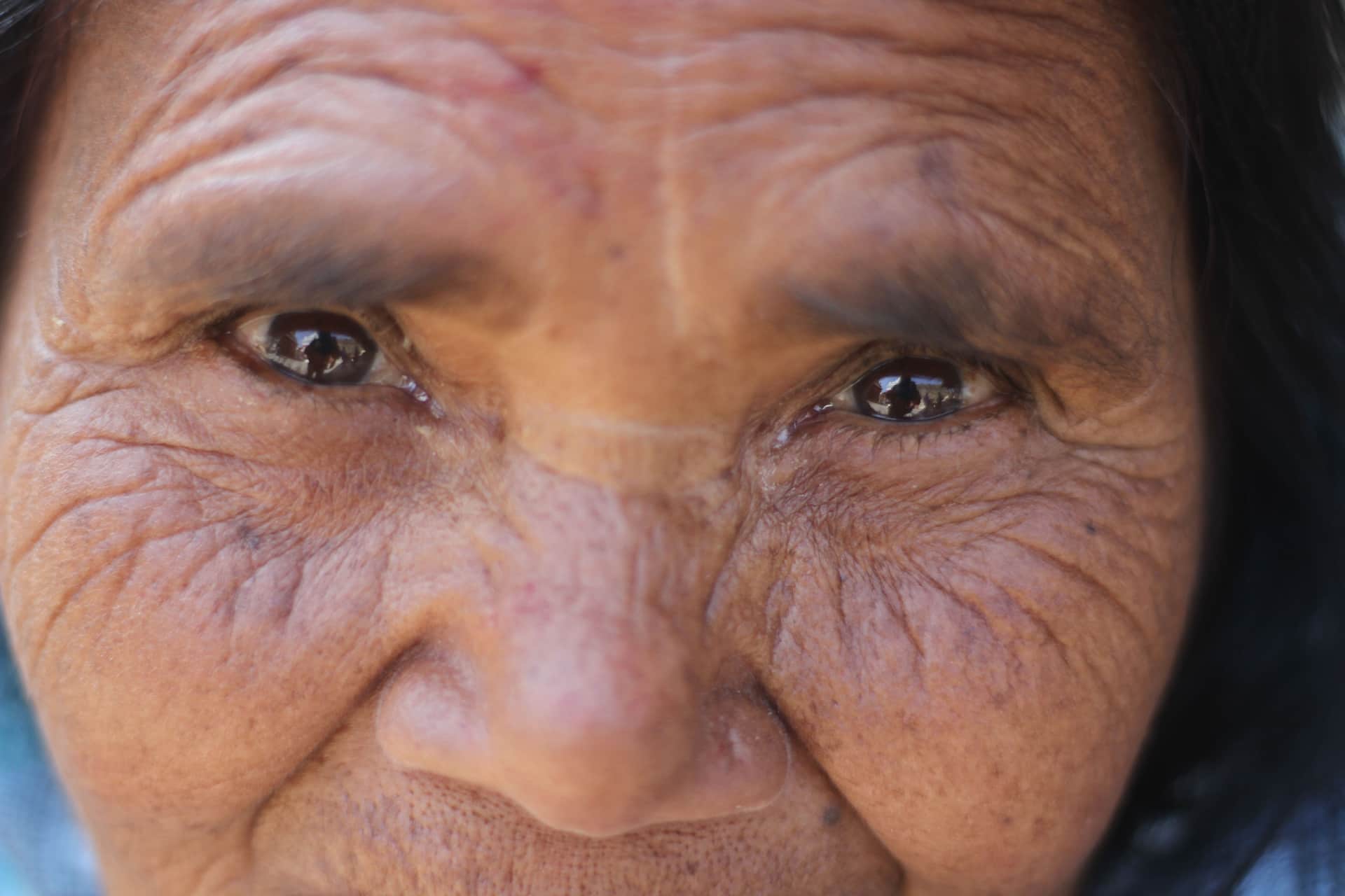 Close-up of an older woman's face showing deep lines around the eyes