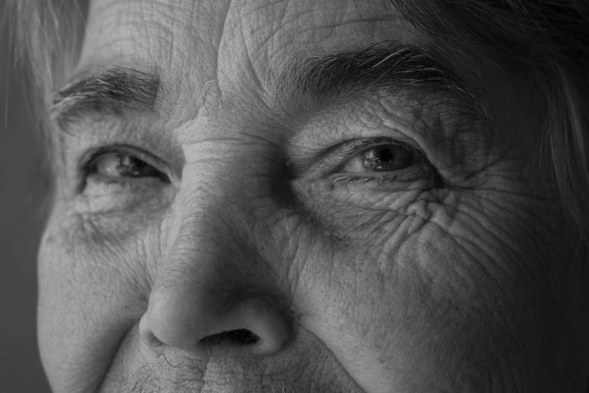 A black and white close portrait showing the detail of an older person's face